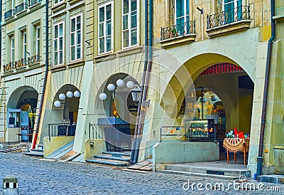 Arcades in medieval townhouses on Kramgasse street is occupied with stores and restaurants in Bern, Switzerland Editorial Stock Photo