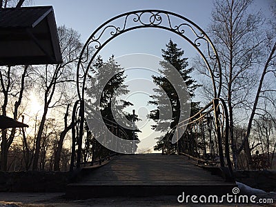Arch of the bridge in the park among the pines Stock Photo
