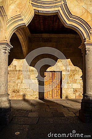 Arch and column of the cloister of the University of Salamanca with its shadow on the wall of the hallway by the light of the Stock Photo