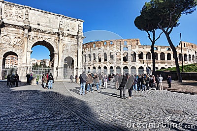 Arch of Constantine and the Colosseum from dei Fori Imperiali street with many tourist in beautiful winter day Editorial Stock Photo