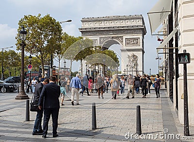 Arch of Triumph from the Avenue des Champs-Elysees. The street is always full of life by tourists and buisness people Editorial Stock Photo