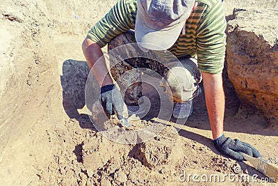 Archaeological excavations. archaeologist with tools conducts research on human burial, skeleton, skull Stock Photo