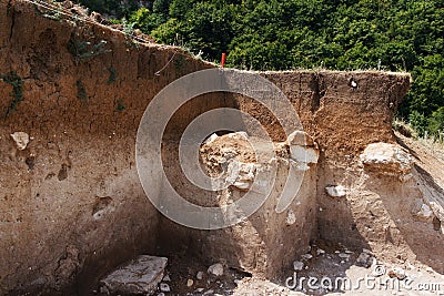 Archaeologists dug a hole on hillside to search for historical artifacts. Archaeological work Stock Photo