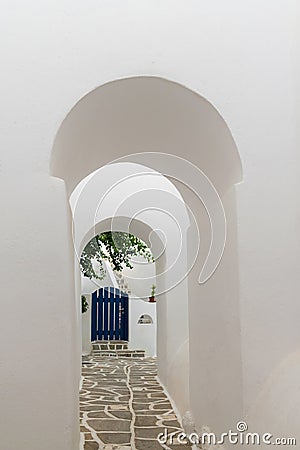 Arched doorways leading to a blue door. Traditional architecture of local villages at Paros island in Greece. Stock Photo