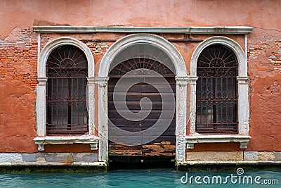 Round arched entrance of a venetian building on a canal in Venice, Italy Stock Photo