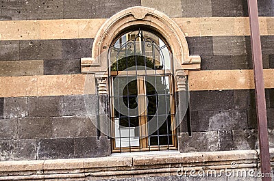 Arched window openings with carved columns and decorative steel grille Stock Photo