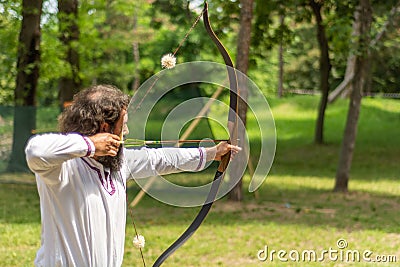 Ancient Precision: Skilled Archer Takes Aim at Medieval Archery Tournament in Forest Setting Editorial Stock Photo