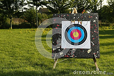 Archery target with arrows in park. Space for text Stock Photo