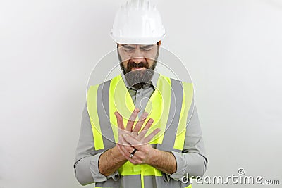 Architect with beard wearing hardhat and reflecting jacket touching painful palm hand Stock Photo