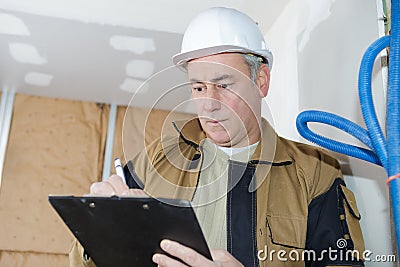 Architect checking insulation during house construction Stock Photo