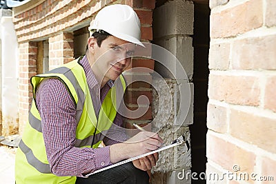 Architect Checking Insulation During House Construction Stock Photo