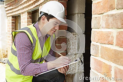 Architect Checking Insulation During House Construction Stock Photo