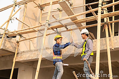 Architect and construction engineer holding hands while working for teamwork and cooperation concept after completing Stock Photo