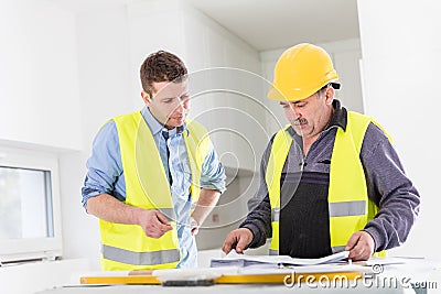 Architect and construction engineer indoor meeting. Stock Photo