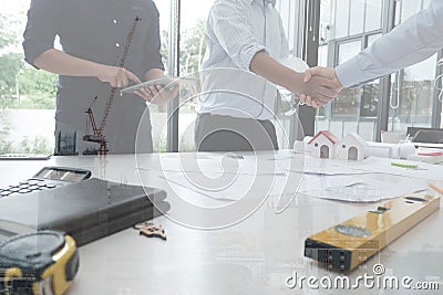 Architect & customer shaking hands. Engineer handshaking with pa Stock Photo