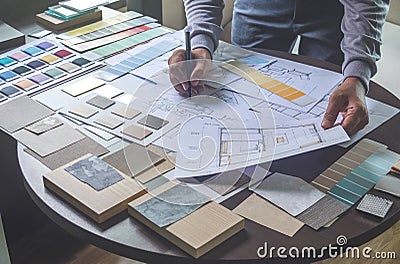 Architect designer Interior creative working hand drawing sketch plan blue print selection material color samples art tools Design Stock Photo