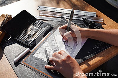 Architect and designer working accurately on a project drawing sketches and technical drafts on paper using professional tools Stock Photo