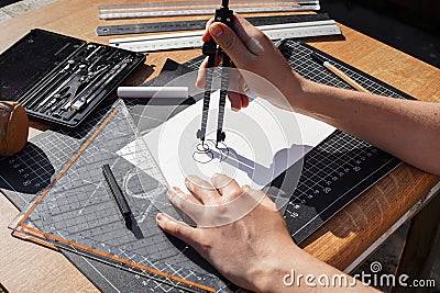 Architect and designer working accurately on a project drawing sketches and technical drafts on paper using professional tools Stock Photo