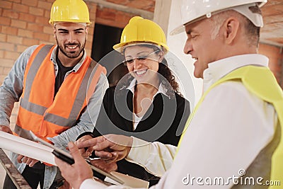 Architect Engineer And Manual Worker Meeting In Construction Site Stock Photo