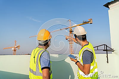 Architect and engineer to inspect and supervise the position of the construction crane at construction site Stock Photo