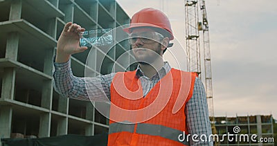 Architect or Engineer using smartphone transparent hologram digital display applicatiion in front of building under Stock Photo