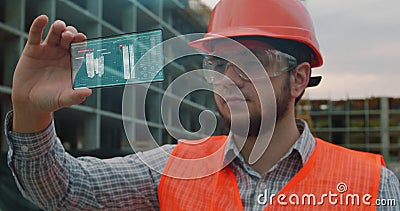 Architect or Engineer using smartphone transparent hologram digital display applicatiion in front of building under Stock Photo