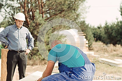 Architect or foreman watching a builder Stock Photo