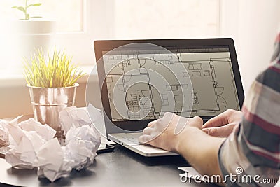 Architect, interior designer working on laptop with floor plans Stock Photo