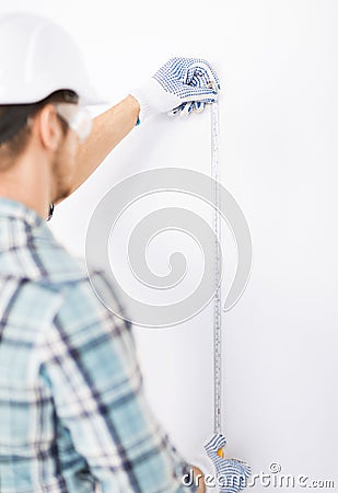 Architect measuring wall with flexible ruler Stock Photo