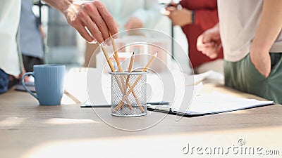 Human hand taking pencil in artist room Stock Photo