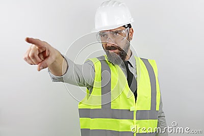 Architect wearing reflecting jacket and hardhat showing and pointing with finger Stock Photo