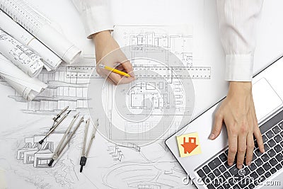 Architect working on blueprint. Architects workplace - architectural project, blueprints, ruler, calculator, laptop and Stock Photo