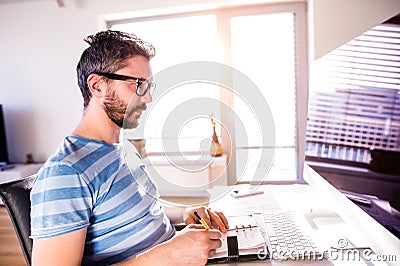 Architect working from home on computer, writing, taking notes Stock Photo