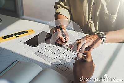 Architects or engineer construction discussing about interior design project with blueprints in architects workplace Stock Photo