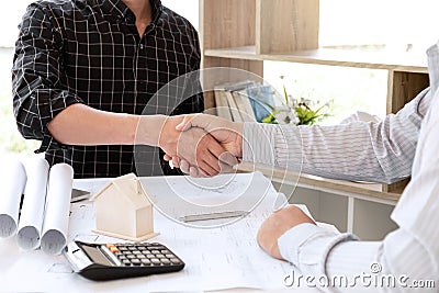 Architects and engineers shake hands while working for teamwork, completing agreements on the office construction site. Successful Stock Photo