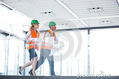 Architects running with blueprint Stock Photo