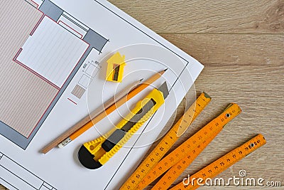 Architectural drawings and pencils, ruler, clerical knife on wooden background. Top view. Repair housing concept Stock Photo