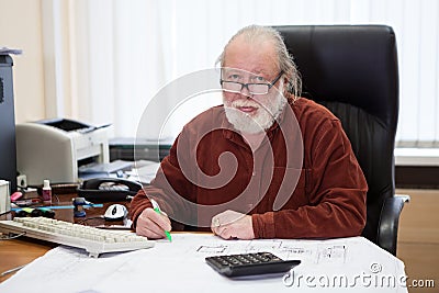 Architectural engineer working with blueprints and documents, writing on drawings. An architect bureau Stock Photo