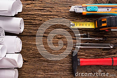 Architectural project, blueprints, blueprint rolls and divider compass, calipers on vintage wooden background. Construction Stock Photo