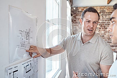 Architecture building presentation drawing, man show client blueprint design on office wall. Customer listening to Stock Photo