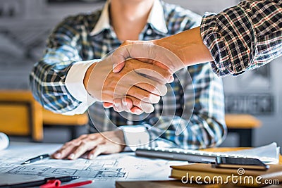 architecture and home renovation concept - builder with blueprint shaking partner hand in retro style Stock Photo