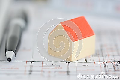 Architecture plans of a building with Small model house on top of blueprints Stock Photo
