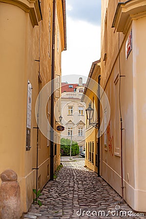 The architecture of the strago city of Prague. Old european streets, yellow low buildings and stone paving stones Editorial Stock Photo