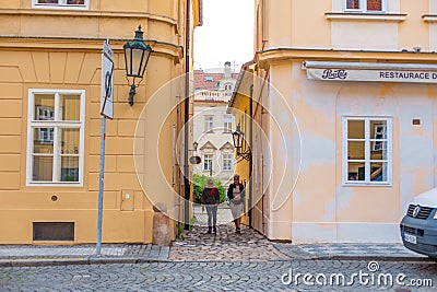 The architecture of the strago city of Prague. Old european streets, yellow low buildings and stone paving stones Editorial Stock Photo