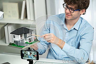 Architecture using house model to teach architect by smartphone. Gusher. Stock Photo