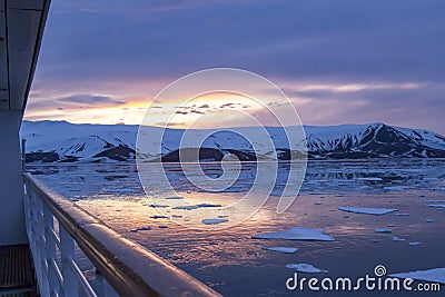 Arctic Glow reflecting in Whalers Bay, Deception Island, Antarctica with cruise deck Stock Photo