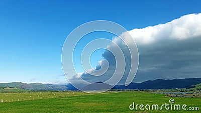 Arcus cloud formation in the form of shelf or rolling clouds over rural mountain landscape Stock Photo