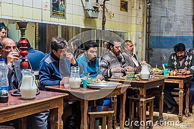 ARDABIL, IRAN - APRIL 10, 2018: People eat Dizi Abgoosht , traditional Iranian stew, in a local tea house in Ardabil, Ir Editorial Stock Photo