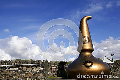 Old copper still at the entrance of the Ardbeg whisky distillery on the isle of Islay Editorial Stock Photo