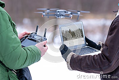 Area planners survey the surroundings with a drone, hands with drone remote controller and a laptop Stock Photo